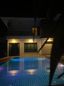 uma piscina à noite em frente a uma casa em Romlaphass Boutique hotel em Kalasin