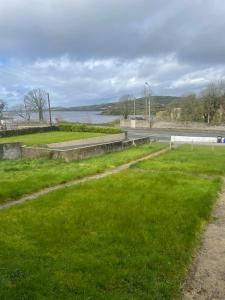 um campo relvado com uma estrada e uma massa de água em Chalet with sea views em Ballyshannon