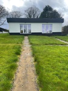 uma casa com uma estrada de terra em frente em Chalet with sea views em Ballyshannon
