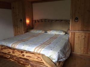 1 dormitorio con 1 cama con pared de madera en Ferienhaus in Pieve Di Bono mit Grill, Garten und Sauna, en Pieve di Bono