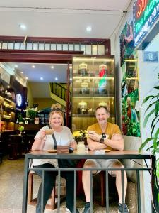 a man and woman sitting at a table in a store at Old Quarter Autumn To Tich Ha Noi in Hanoi