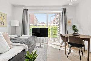 Sala de estar con cama, mesa y TV en Studio from paradise, en Aarhus
