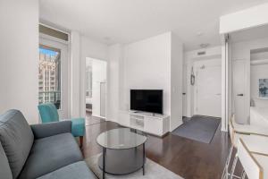 a living room with a couch and a tv at 2 BR with Amazing city views, Free parking and pool in Toronto