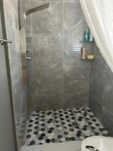 baño con ducha y suelo blanco y negro en Villa Pulido-Cardona, en Miami Gardens