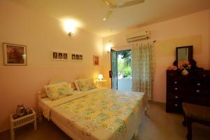 a bedroom with a bed and a dresser and a window at Bella Homestay Kerala in Alleppey