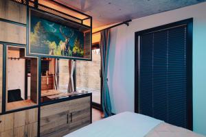 a bedroom with a bed and a dresser with a mirror at Pasul Palma Village-Mirror House in Suceava