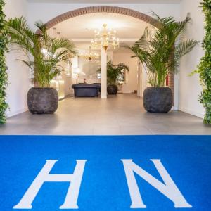 eine Lobby mit einem blauen Teppich und Palmen in der Unterkunft Hotel Nettuno in Lido di Jesolo
