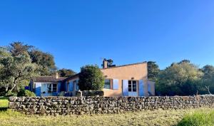 una casa detrás de una pared de piedra delante en Le petit Fauchon - Villa avec vue mer, en Île-dʼAix