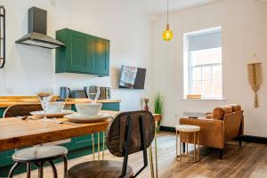 une cuisine avec une table en bois et des armoires vertes dans l'établissement Guest Homes - Foregate Studio Apartment, à Worcester
