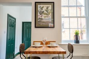 - une salle à manger avec une table et des chaises en bois dans l'établissement Guest Homes - Foregate Studio Apartment, à Worcester