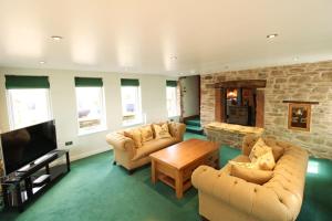 a living room with two couches and a tv at The Gardeners Cottage, Hutton John is a luxurious cottage with hot tub 10 minutes from Lake Ullswater in Penruddock