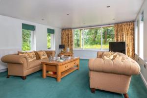 a living room with two couches and a coffee table at The Gardeners Cottage, Hutton John is a luxurious cottage with hot tub 10 minutes from Lake Ullswater in Penruddock