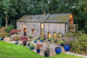 an old stone cottage with a lot of plants at The Gardeners Cottage, Hutton John is a luxurious cottage with hot tub 10 minutes from Lake Ullswater in Penruddock +22 photos