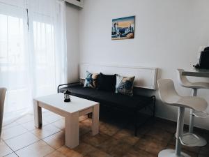 een woonkamer met een bank en een tafel bij Nautilus City Studios & Apartments in Rhodos-stad