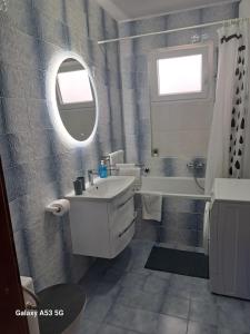 La salle de bains est pourvue d'un lavabo, d'une baignoire et d'un miroir. dans l'établissement Apartment Lavanda Nova, à Ražanj
