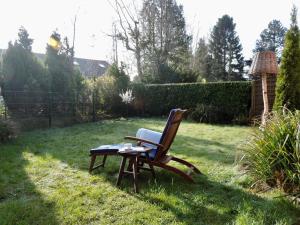 uma cadeira sentada na relva num quintal em Ferienhaus in Blandorf-Wichte mit Garten und Terrasse em Hage
