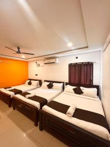 a room with three beds in it at The Ocean Edge in Puducherry