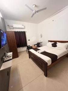 um quarto com uma cama grande e uma ventoinha de tecto em The Ocean Edge em Pondicherry