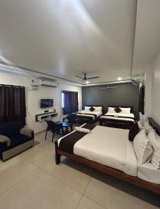 a large bedroom with two beds and a couch at The Ocean Edge in Puducherry