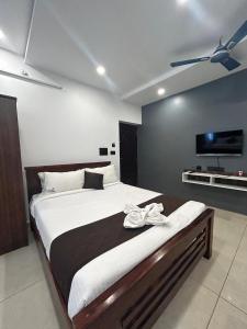 sypialnia z dużym łóżkiem i telewizorem z płaskim ekranem w obiekcie The Ocean Edge w mieście Puducherry