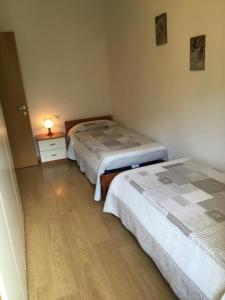 1 dormitorio con 2 camas y mesa con lámpara en Appartement in Tiarno Di Sotto, en Tiarno di Sotto