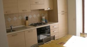 cocina con fogones y mesa con sillas en Appartement in Tiarno Di Sotto, en Tiarno di Sotto