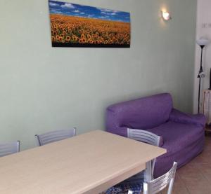 sala de estar con mesa y sofá púrpura en Appartement in Tiarno Di Sotto en Tiarno di Sotto