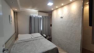 a small room with a bed and a shower at Angel Hospedagem de quartos in Vila Velha
