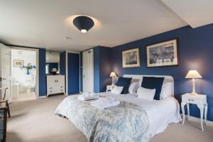 a bedroom with a large bed with blue walls at Tapnell Manor At Tapnell Farm in Yarmouth