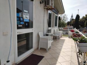 an outdoor patio with white chairs and a building at Alloggio Turistico in Focene