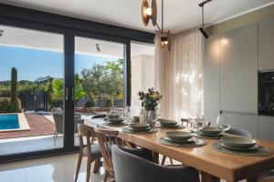 uma sala de jantar com mesa e cadeiras de madeira em Villa Maria Luisa em Pula
