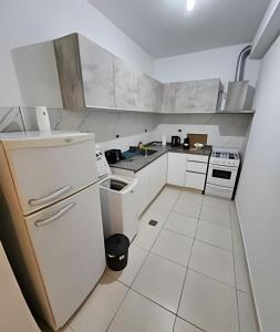 a kitchen with white appliances and white tile floors at Dúplex Dorrego in Barraquero
