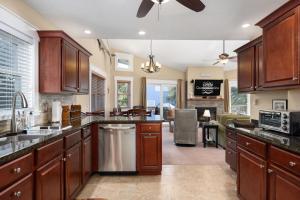 a kitchen with wooden cabinets and a living room at SH101 Reel Catch in Southern Shores