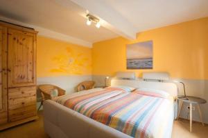 - une chambre avec un lit et des murs jaunes dans l'établissement Appartement in Pellworm mit Garten, Terrasse und Grill, à Pellworm