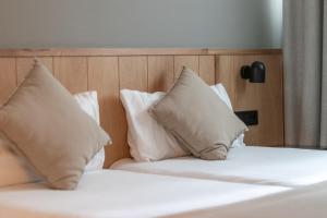 two beds with white pillows in a bedroom at Old Town Apartments by Staynnapartments in Bilbao