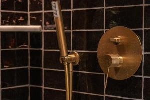a toilet paper dispenser in a bathroom with black tiles at Old Town Apartments by Staynnapartments in Bilbao +123 photos