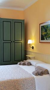 1 dormitorio con 2 camas y armario verde en Casa Di Pam, en Scicli