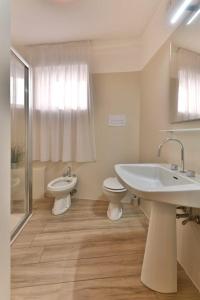 ein Badezimmer mit einem Waschbecken, einem WC und einem Waschbecken in der Unterkunft Apartment Fico in Tignale