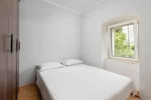 a white bedroom with a bed and a window at villa branka in Strp