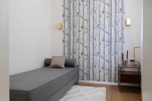 a living room with a couch and a tree mural at Villa Keller in Balatonboglár