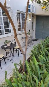 eine Terrasse mit einem Tisch, Stühlen und einem Baum in der Unterkunft Alexandros Apartment in Athen