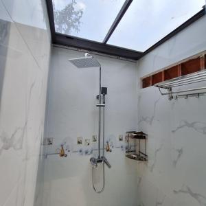 um chuveiro na casa de banho com um tecto de vidro em Nhà bên hồ sen em Bao Loc