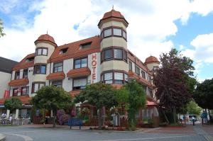 un edificio alto con un cartel en el costado en Hotel Restaurant Paelzer-Buwe, en Hassloch