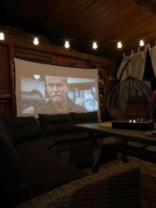 a movie screen in a living room with a couch at Guest House Eden in Bihać +33 photos