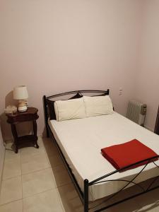 um quarto com uma cama com uma toalha vermelha em Villa Anna em Amaliapoli