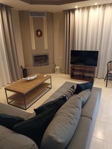 uma sala de estar com um sofá e uma mesa em Villa Anna em Amaliapoli