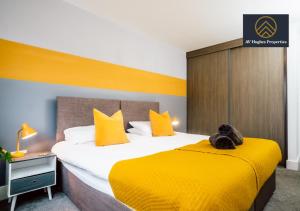 a hotel room with a large bed with yellow sheets at Exclusive Apartment by AV Hughes Properties Short Lets & Serviced Accommodation Milton Keynes with Fast Wi-Fi in Milton Keynes