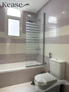 een badkamer met een toilet, een douche en een bad bij Kease Qurtubah A-19 Royal Design GX10 in Riyad