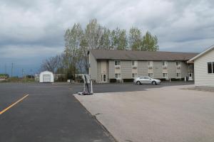a parking lot in front of a large building at American Host Inn in Hart