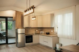 uma cozinha com armários brancos e um frigorífico de aço inoxidável em Kuća za odmor Kamena em Grude